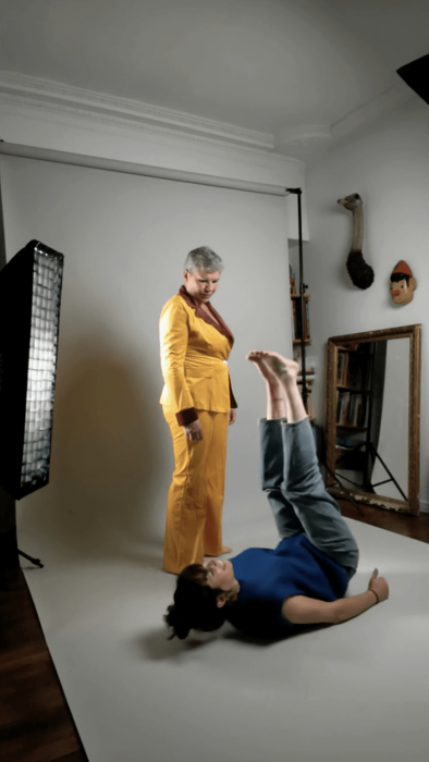 Photographe montrant une pose pendant une séance photo en studio